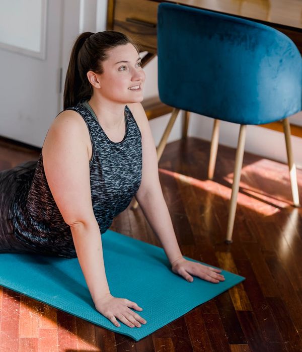 Woman performing a morning yoga stretch in a bright room.
